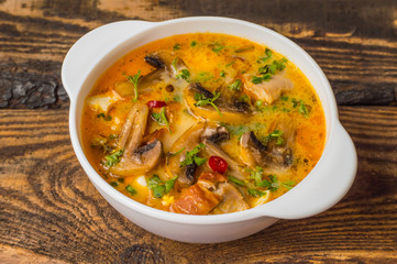 Delicious soup with smoked chicken, mushrooms,  eggs and cream. Wooden background