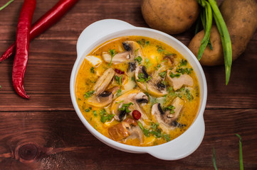 Delicious soup with smoked chicken, mushrooms,  eggs and cream. Wooden background