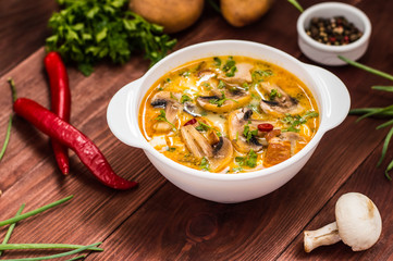 Delicious soup with smoked chicken, mushrooms,  eggs and cream. Wooden background