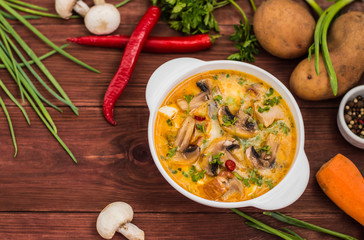 Delicious soup with smoked chicken, mushrooms,  eggs and cream. Wooden background