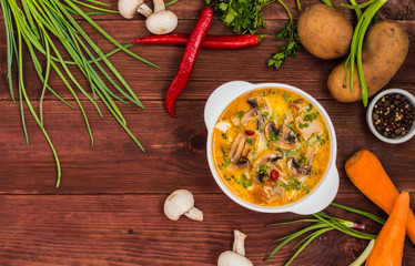 Delicious soup with smoked chicken, mushrooms,  eggs and cream. Wooden background