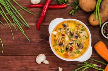 Delicious soup with smoked chicken, mushrooms,  eggs and cream. Wooden background