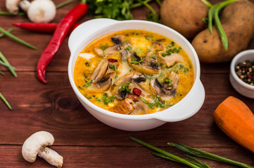 Delicious soup with smoked chicken, mushrooms,  eggs and cream. Wooden background