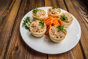 Tartlets with pate of fish and greens on a wooden old background. Top view. Close-up