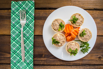 Tartlets with pate of fish and greens on a wooden old background. Top view. Close-up