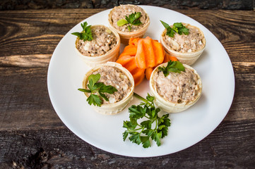 Tartlets with pate of fish and greens on a wooden old background. Top view. Close-up