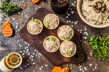 Tartlets with pate of fish and greens on a wooden old background. Top view. Close-up
