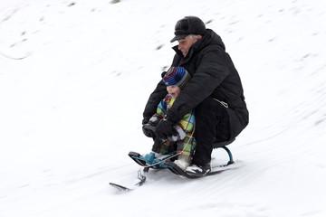 Grandfather with grandson ride sled