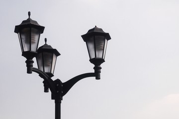 Fototapeta na wymiar 3 ways electric lamp post againt clear blue sky