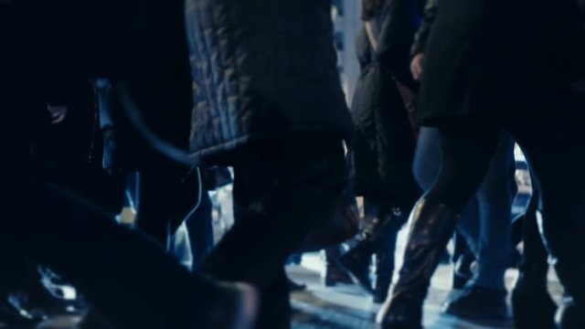 Pedestrians on cold winter night, cross busy city street, slow motion 100p.tracking shot of an anonymous crowd of pedestrians crossing a busy city street.No logos or faces visible.Commercial shot.
