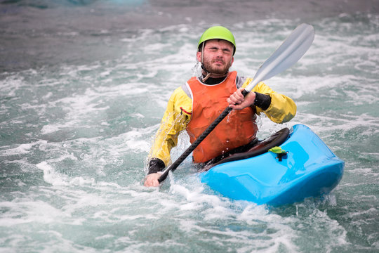 Young man gets face full of water in kayak