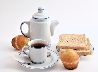 Rebanadas de pan, magdalenas y té.