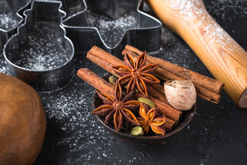 Cooking traditional biscuits and gingerbread. Christmas. New year. Dough, cutting the cookies and the spices on the table. Cinnamon sticks, cardamom, nutmeg, star anise
