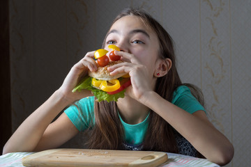11 year old girl with pleasure eats a hamburger