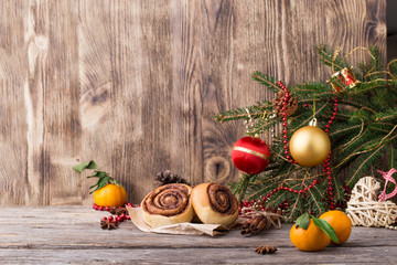 Christmas card. New year composition with cinnamon rolls, tangerines (mandarin), baubles, spices and fir branch