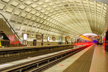 Interior View of an Underground Station with a  Train Leaving the Platform