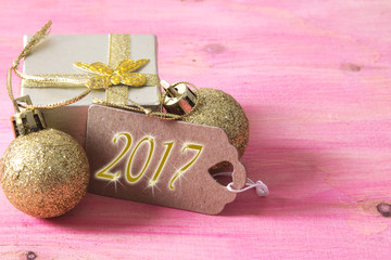happy new year card with gift box and tag on pink wooden bakckground