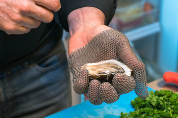 Fresh oyster held open with a oyster knife
