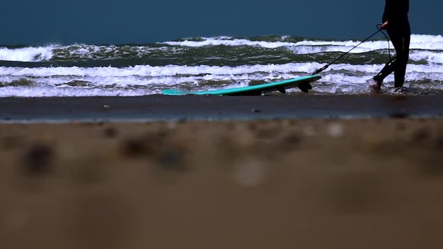 Surfer walking with long surf boards on beach