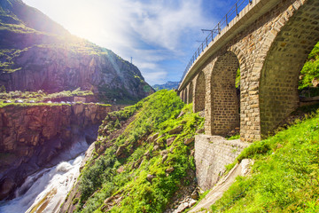 Railway bridge Teufelsbrucke over Reuss river in St. Gotthard mountain range of Swiss Alps near Andermatt