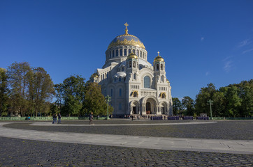 Fototapeta na wymiar Naval Cathedral of St. Nicholas and the square with tourists and young naval cadets in Kronstadt at Sunny day. Russia