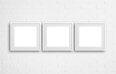 Three  blank frames on white bricks textured wall