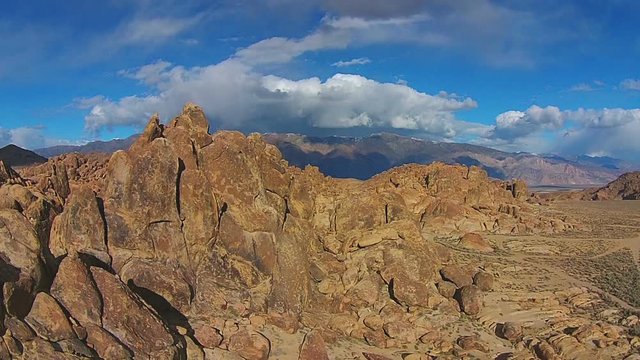 Footage - Aerial view of Alabama Hills with mountain top and clouds at the background