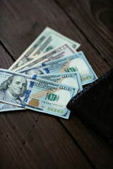 Dollars curence. Dollars banknotes with wallet on brown wooden table. Dollars cash. Closeup. 