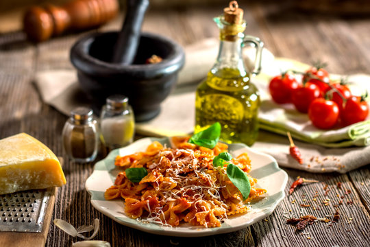 Pasta with tomato sauce on wooden background
