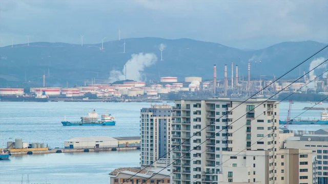 Gibraltar View to Refineries at Puente Mayorga Spain with Cargo Ships in the Bay and Apartment Buildings against the Harbor Water