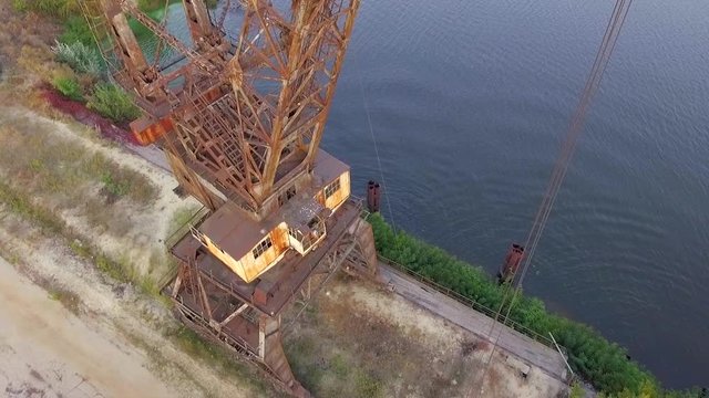 Aerial footage. ?amera moves in to the cabin of the old gantry crane.