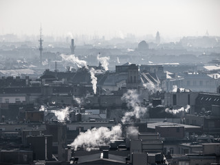 Smog - city air pollution. Unclear foggy atmosphere polluted by smoke rising from the chimneys in the urban city centre and silhouettes of rooftops, Budapest, Hungary
