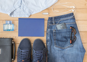 Men's jeans and accessories on the wooden floor.