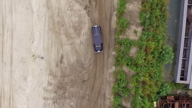 Aerial footage. Pursuit of a vintage car on the sandy shore.
