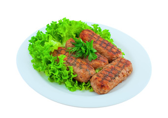 Meat cutlets fried on the grill lay on the leaves of lettuce on a white plate. Fatty foods fast food.