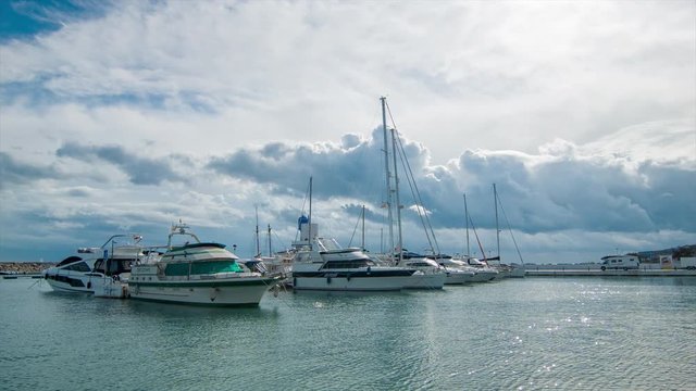 Boats and Yachts in Puerto de la Duquesa Marina with Dramatic Clouds in the Sky on a Calm Day in Southern Spain
