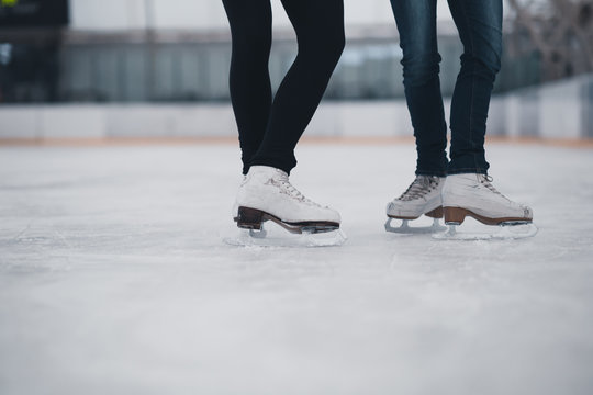 Friends on skates at ice-skating rink.