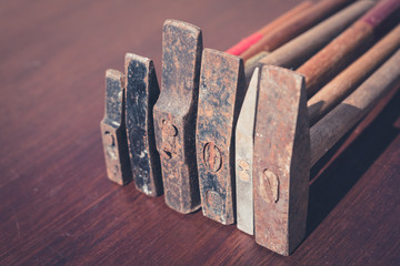 row of old hammers on wooden table - vintage tools