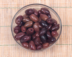 Jumbo pitted kalamata olives in bowl on bamboo placemat