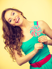 Woman charming girl with lollipop candy