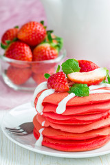 Stack of red velvet pancakes with yogurt and strawberry on white plate, vertical
