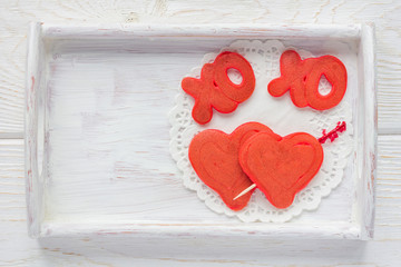 Red velvet pancakes with xo sign (hugs and kisses) and heart on wooden tray, horizontal, top view, copy space