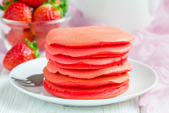 Stack of red velvet pancakes on white plate, horizontal