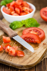 Tomatoes (diced) on wooden background (selective focus)
