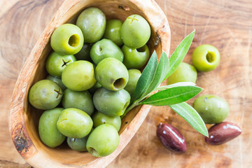 Green olives/ Bowl filled with freshly harvested whole fresh green olives in the olive wood bowl.