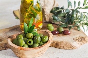 Green olives and olive oil/green olives in olive wood bowl and mixed olives and in the bowl next to Olive lives.