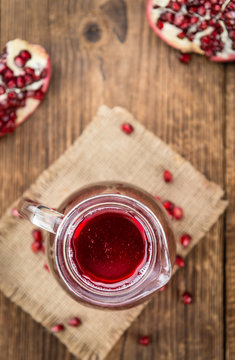 Fresh made Pomegranate juice on rustic background