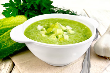 Soup cucumber with peppers in white bowl on light board