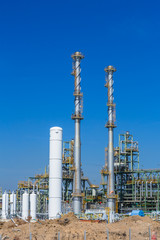 Refinery tower in petrochemical industrial plant with cloudy sky