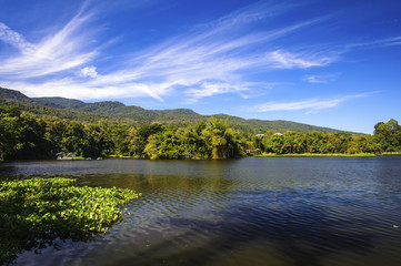 Fototapeta na wymiar Reservoir under blue sky with a mountain backdrop